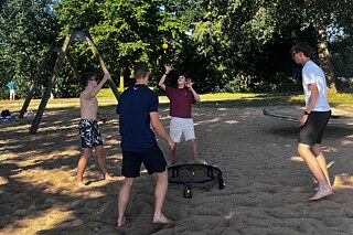 Jugendliche spielen Spikeball.
