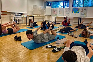 Jugendliche üben Yogastellungen.