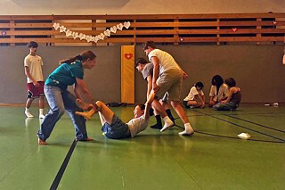 Jugendliche haben Spaß in einer Sporthalle.