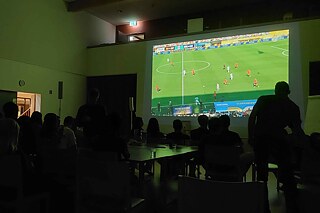 Jugendliche sehen das WM-Finale auf einem großen Bildschirm.