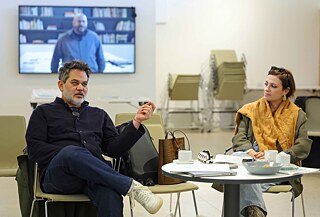Two participants take part in a discussion in an event space.