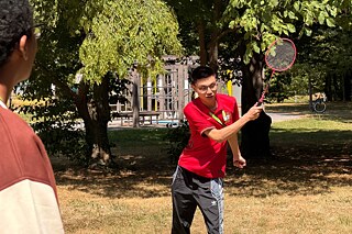 Jugendliche spielen Federball in einem Park.