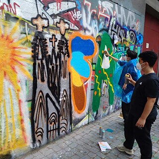 Jugendliche sprühen Graffiti.