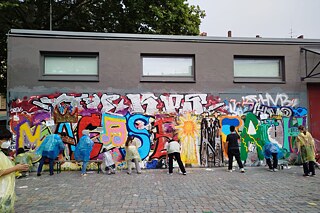Jugendliche sprühen Graffiti.