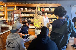 Eine Gruppe Jugendlicher lauschen einem Vortrag im Schokoladenmuseum in Köln.