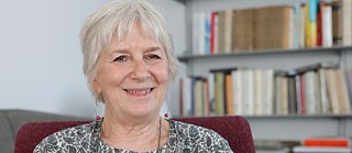 Porträt der Übersetzerin Anita Raja; im Hintergrund ein Bücherregal