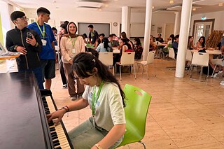 Jugendliche am Klavier im Aufenthaltsraum des Goethe-Instituts Schwäbisch Hall