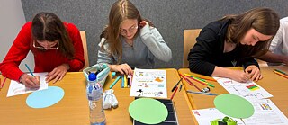 Zwei Jugendliche arbeiten konzentriert an einem Tisch in einem Unterrichtsraum.