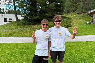 Zwei Jugendliche tragen Sonnenbrille und auf dem T-Shirt steht „Peace-Polizei“