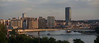 A highrise in the middle of a city by a river