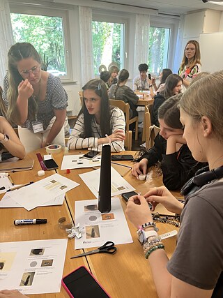  Учасники академії працюють у групах над практичним завданням, досліджують наукові явища.