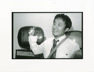 Nam June Paik vor dem Werk „Live Fish“ im Whitney Museum of Art, 1982. Sammlung Paul Garrin. Archiv des Nam June Paik Art Center. Mit freundlicher Genehmigung des Nam June Paik Art Center.