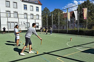 Jugendliche spielen Wikingerschach auf einem Sportplatz.
