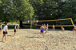 Jugendliche spielen Beachvolleyball.