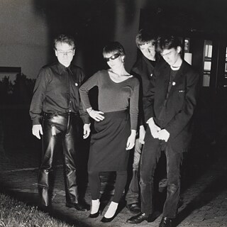 Four members of the band NO MORE in front of a building