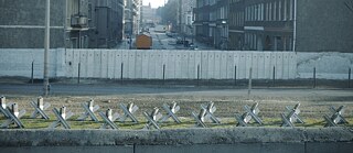 Blick aus Westberlin nach Ostberlin – eine Straße ist durch den Mauerstreifen getrennt