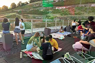 Jugendliche bei Sonnenuntergang auf einer Dachterrasse