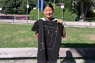 Jugendliche präsentiert ihr selbst gestaltetes T-Shirt.