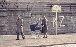 Eine Familie spaziert am Grenzstreifen an der Bernauer Straße entlang.