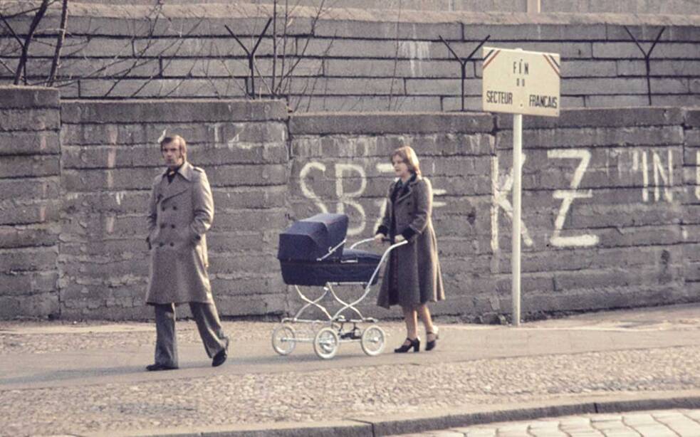 Eine Familie spaziert am Grenzstreifen an der Bernauer Straße entlang.