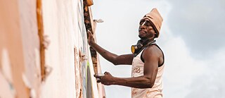 Man on scaffolding by building wall