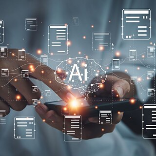 Symbolbild für Künstliche Intelligenz: Eine Hand berührt mit dem Finger ein Smartphone, verschiedene symbolische Nachrichten erscheinen im Vordergrund. Mittig ein angedeutetes Gehirn mit den Buchstaben "AI" für Artificial Intelligence.