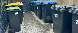 Mülltonnen in Bonn, Deutschland: gelb für Plastik, grün für Bioabfälle, blau für Papier und schwarz für Restmüll.