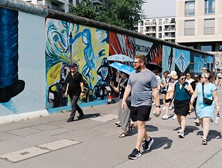 The TOP 1 2026 group walks along the Eastside Gallery in Berlin.