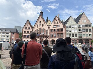 The TOP 2 2026 study tour group stands in front of historical buildings in the Frankfurt city center.