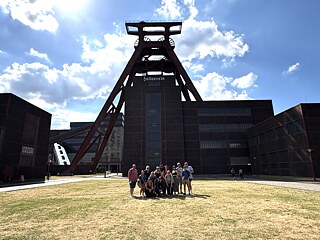 The TOP 2 2026 study tour group stands in front of the Zollverein coal mine.