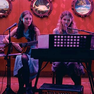 Zwei Mädchen musizieren.