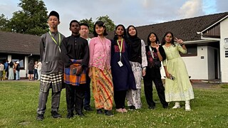 Ein Gruppenfoto der malaysischen Teilnehmer*innen in traditioneller Kleidung, aufgenommen nach dem Länderabend. 