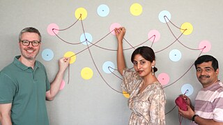 Three people standing with a thread connected 
