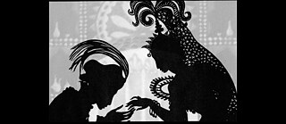 Black-and-white silhouette scene featuring two figures facing one another. One figure wearing a turban leans forward, while the other wears an elaborately decorated headdress. The figures extend their hands toward each other against an ornamental background.
