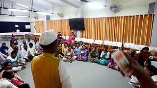 One person standing int he foreground with his back to the camera