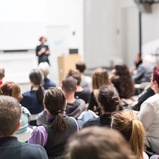 Eine Frau spricht vor Publikum in einem Hörsaal