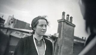Schwarz-Weiß-Fotografie von Hannah Arendt als Halbporträt vor einem urbanen Hintergrund.