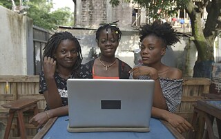 Drei schwarze Frauen vor einem PC