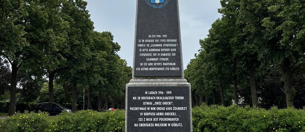  Gedenksäule im Paderewski-Park in Zgorzelec, an der Stelle des ehemaligen „griechischen Lagers“. Die Inschrift (auf Griechisch, Polnisch und Deutsch) erinnert an die Präsenz des IV. griechischen Armeekorps in der Region in den Jahren 1916–1919.