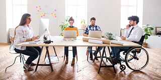 A group of learners sits together at a desk.