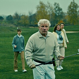 escena de la película WIR KÖNNTEN GENAUSO GUT TOT SEIN Grupo de personas caminando en un campo con palos de golf en las manos