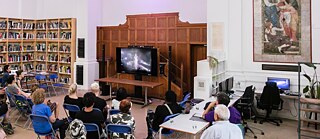 Artist sitting watching a video