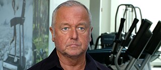 Close up of an older white man facing the camera in a sport studio 