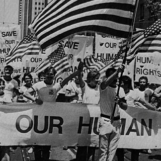 Black and white photo of street protesters holding up placards with the demand "Save our Human Rights"
