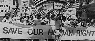 Black and white photo of street protesters holding up placards with the demand "Save our Human Rights"