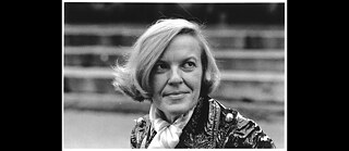 Black and white photo of a white woman with blond chin-length hair looking outsight the frame to the right