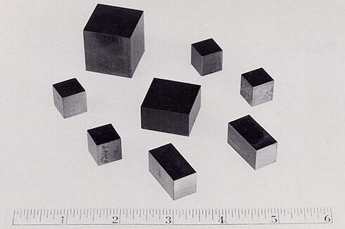 Este metal radioactivo, utilizado en la industria militar y como fuente de poder en plantas nucleares, abunda en países africanos como Níger, que posee las mayores concentraciones del metal y es también uno de los países más pobres del mundo. Muchos países de Europa que dan auxilios a países como Níger lo hacen a un alto precio: la explotación de su uranio, que los priva del producto que podría dar un vuelco definitivo a su suerte. (Foto: Cubos de uranio, parte de la producción de la primera bomba nuclear, 1942, U.S.A. Department of Energy – PD)