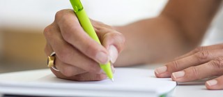Eine Hand mit grünem Stift füllt ein Formular aus. © Foto: Goethe-Institut/Bettina Siegwart Anmeldung Deutschprüfungen