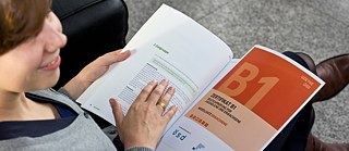 A young woman browsing through an exam brochure. 