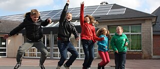 Des élèves dans la cour de l’école normande qui, grâce à « Energie partagée », produit de l'énergie solaire sur le toit.